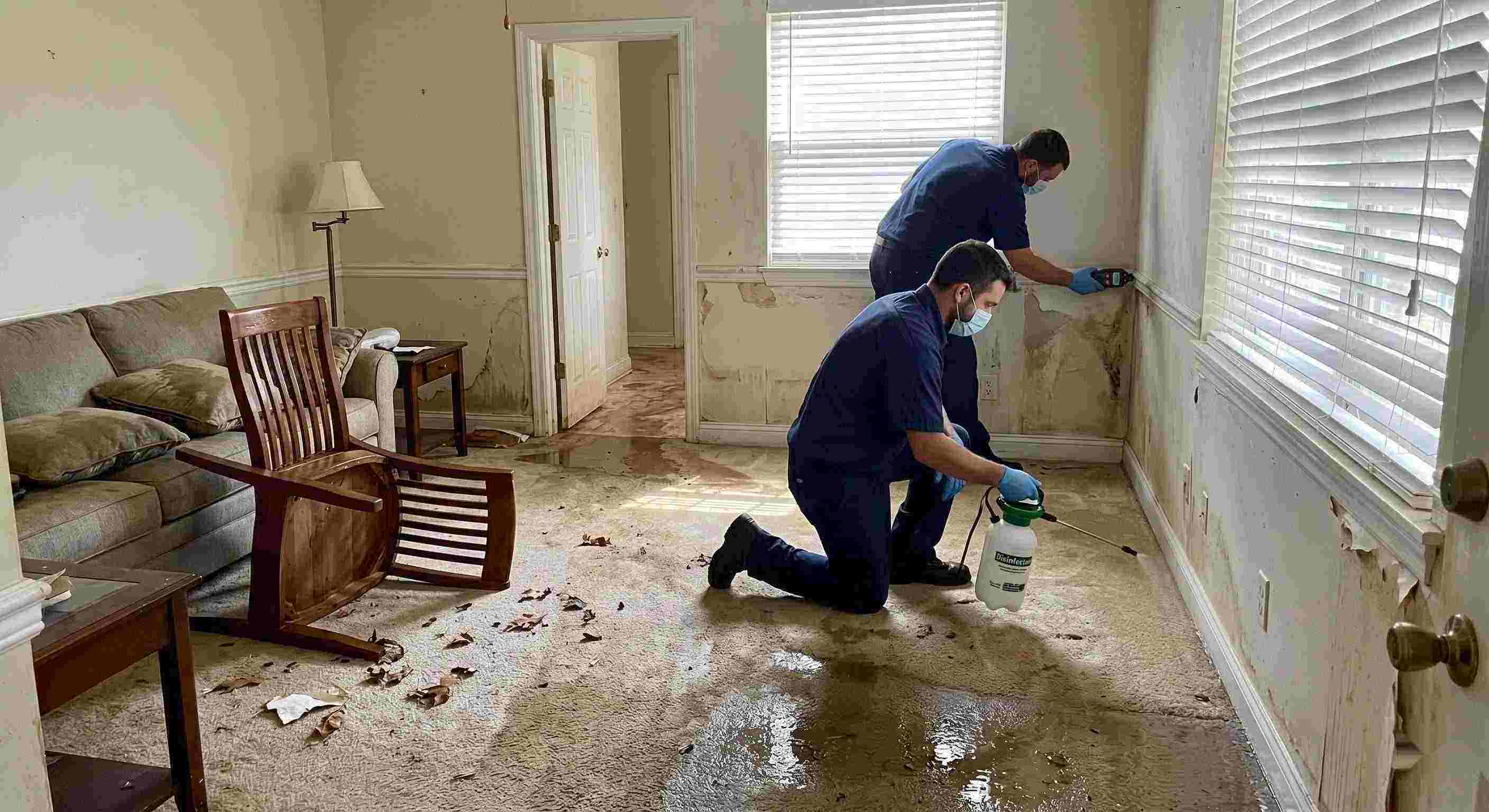 Technicians performing flood disinfection after water damage inside a home in Baltimore, ensuring wet floors, damp walls, and household items are sanitized safely.