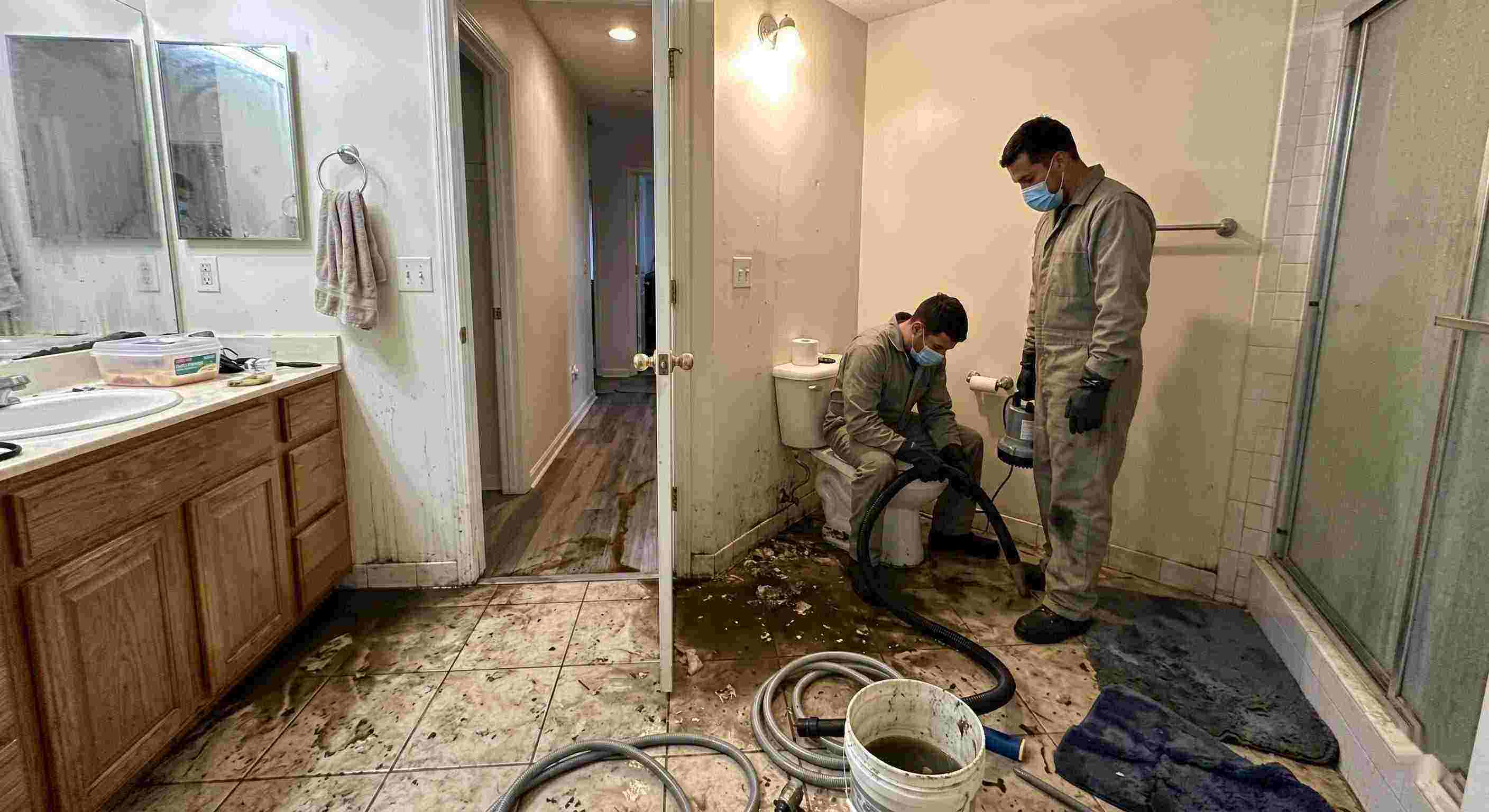 Septic tank backup cleanup in Baltimore bathroom with technicians removing contaminated water and sanitizing affected areas